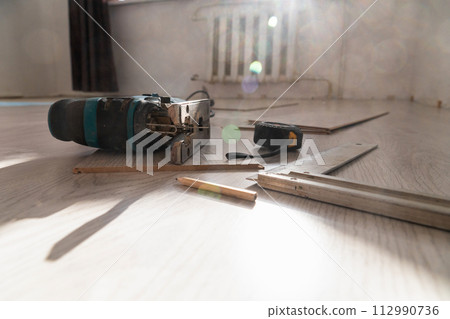 Sawing laminate. Repairing the floor in the house, laminate flooring. Sawing laminate. Repairing the floor in the house, laminate flooring. 112990736