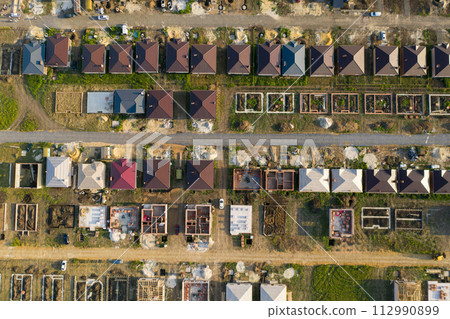 Construction of a suburban neighborhood of cottages. Aerial view. Construction of a suburban neighborhood of cottages. Aerial view. 112990899