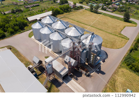 Aerial view of agricultural silos, grain elevator for storage and drying of cereals. Aerial view of agricultural silos, grain elevator for storage and drying of cereals. 112990942