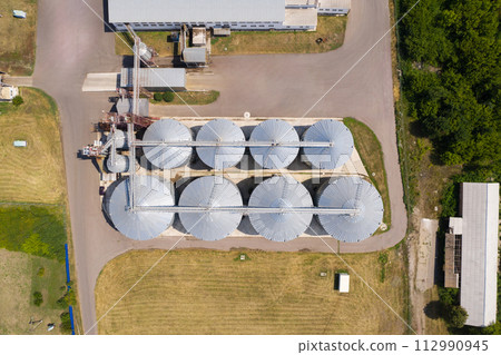 Aerial view of agricultural silos, grain elevator for storage and drying of cereals. 112990945