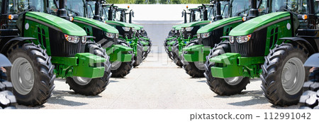 A row of green agricultural tractors A row of green agricultural tractors 112991042