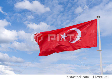 The Turkish flag flutters in the wind. State symbol of Turkey. The Turkish flag flutters in the wind. State symbol of Turkey. 112991050