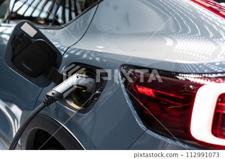 Close up of electric car inlet with a connected charging cable Close up of electric car inlet with a connected charging cable 112991073