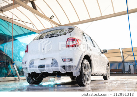 Self service high pressure car wash. Vehicle covered with foam 112991318