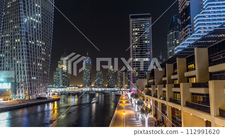 Promenade and canal in Dubai Marina timelapse at night, UAE. Promenade and canal in Dubai Marina timelapse at night, UAE. 112991620
