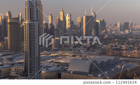 Dubai downtown skyline day to night timelapse. Rooftop view of Sheikh Zayed road with numerous illuminated towers. Dubai downtown skyline day to night timelapse. Rooftop view of Sheikh Zayed road with numerous illuminated towers. 112991634