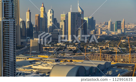 Dubai downtown skyline timelapse at sunset time. Rooftop view of Sheikh Zayed road with numerous towers. Dubai downtown skyline timelapse at sunset time. Rooftop view of Sheikh Zayed road with numerous towers. 112991635
