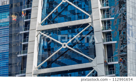 Washers wash the windows of modern skyscraper in Dubai timelapse 112991654