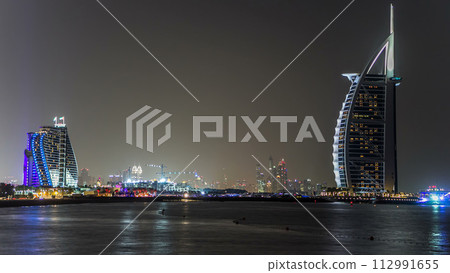 Dubai skyline with Burj Al Arab hotel at night timelapse. 112991655