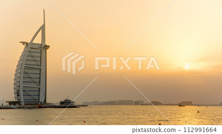 Dubai skyline with Burj Al Arab hotel during sunset timelapse. 112991664