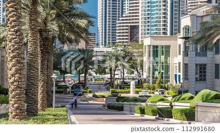 Fountain and palms timelapse at the Marina walk during day time. Dubai, UAE 112991680