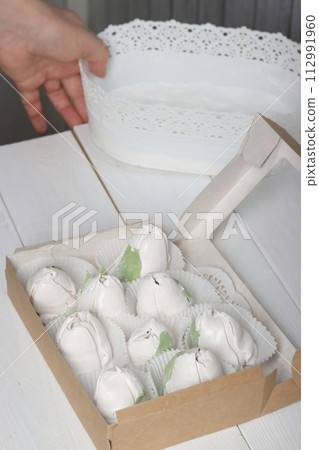 A woman puts homemade marshmallows into boxes. 112991960
