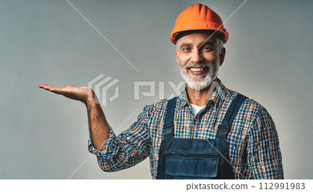 Portrait on mature happy handyman presenting something 112991983