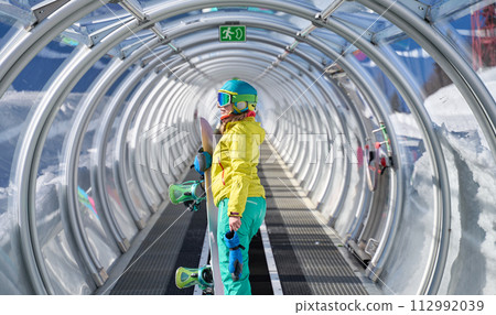 Snowboarder in Mountain Transit Tube 112992039