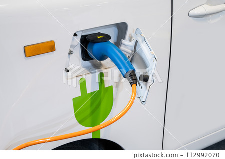 Close up of electric car inlet with a connected charging cable Close up of electric car inlet with a connected charging cable 112992070