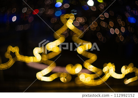 Blurred holiday background with bokeh. Defocused New Year and Christmas illumination Blurred holiday background with bokeh. Defocused New Year and Christmas illumination 112992152