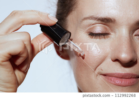 Closeup on relaxed young female with cosmetic elixir Closeup on relaxed young female with cosmetic elixir 112992268