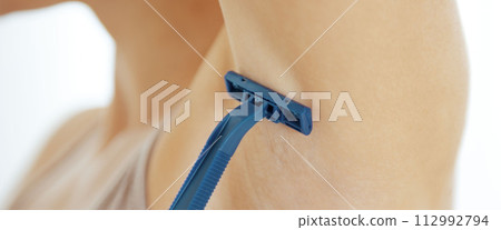 Closeup on young woman shaving armpit 112992794
