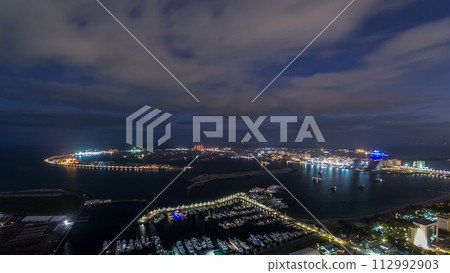 Jumeirah Palm Island night to day timelapse dubai shot from the rooftop top of the tower in dubai marina, uae Jumeirah Palm Island night to day timelapse dubai shot from the rooftop top of the tower in dubai marina, uae 112992903