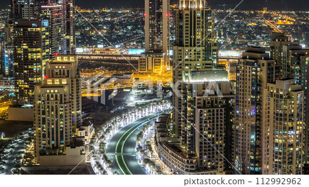 Top view of road in Dubai downtown timelapse with night traffic and illuminated skyscrapers. 112992962