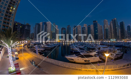Dubai Marina at Blue hour night to day timelapse with yachts 112993088