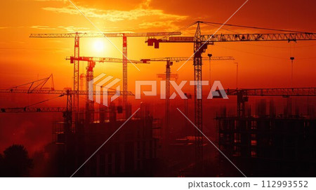 Construction cranes above the unfinished residential building against sunshine. Housing construction, apartment block in city 112993552