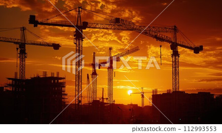 Construction cranes above the unfinished residential building against sunshine. Housing construction, apartment block in city 112993553