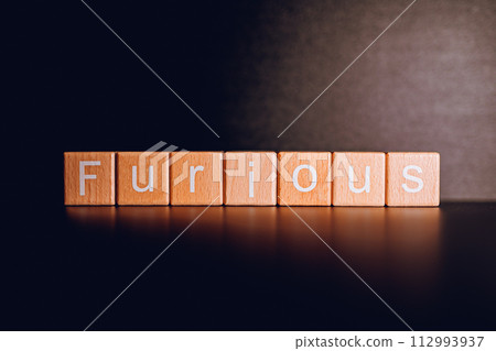 Wooden blocks form the text "Furious" against a black background. Wooden blocks form the text "Furious" against a black background. 112993937