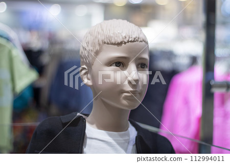 Baby mannequin in bright clothes in store 112994011