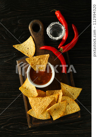 Nachos with tequila and chili pepper on a dark background 112994320