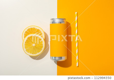 Tin can, orange and straw on orange background, top view Tin can, orange and straw on orange background, top view 112994350