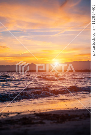 beautiful sunset over calm sea, waves of water and clean sand, Salou, Spain beautiful sunset over calm sea, waves of water and clean sand, Salou, Spain 112994403