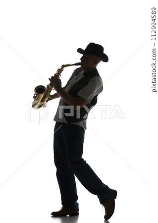 Silhouette of man in classical suit playing saxophone isolated on white background. Black and white image. 112994589
