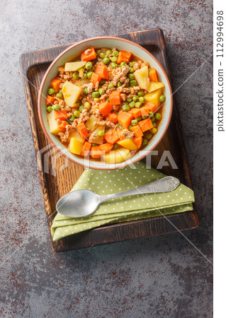 Turkish stew Kiymali bezelye yemegi with green peas, minced meat and vegetables closeup on the plate. Vertical top view Turkish stew Kiymali bezelye yemegi with green peas, minced meat and vegetables closeup on the plate. Vertical top view 112994698