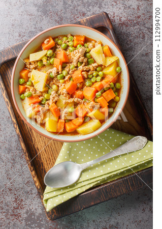 Turkish food Green Peas with Ground Beef stew Kiymali Bezelye closeup on the plate. Vertical top view Turkish food Green Peas with Ground Beef stew Kiymali Bezelye closeup on the plate. Vertical top view 112994700