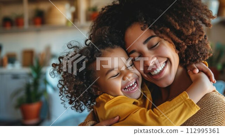 Affectionate loving middle aged mother cuddling child. Excited to see daughter, happy senior older mom cuddling her, sitting together on comfortable sofa in living room 112995361
