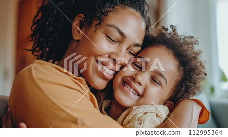 Affectionate loving middle aged mother cuddling child. Excited to see daughter, happy senior older mom cuddling her, sitting together on comfortable sofa in living room 112995364