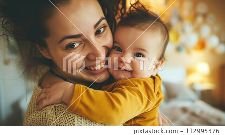 mother cuddling her baby with smile on their faces and adorable look on baby face 112995376