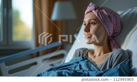 Young cancer woman lying in hospital bed 112995903