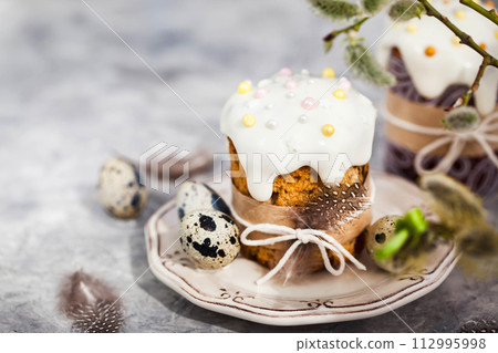 Sweet Easter bread, panettone or kulich and colorful painted eggs, Holiday spring concept Sweet Easter bread, panettone or kulich and colorful painted eggs, Holiday spring concept 112995998