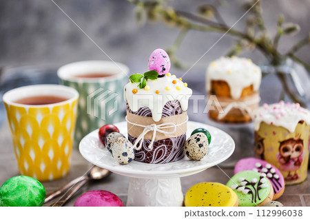 Sweet Easter bread, panettone or kulich and colorful painted eggs, Holiday spring concept Sweet Easter bread, panettone or kulich and colorful painted eggs, Holiday spring concept 112996038