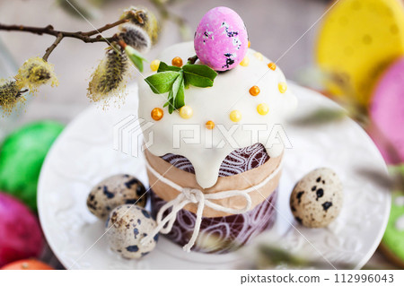 Sweet Easter bread, panettone or kulich and colorful painted eggs, Holiday spring concept Sweet Easter bread, panettone or kulich and colorful painted eggs, Holiday spring concept 112996043