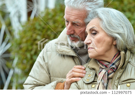 Portrait of sad senior couple in park Portrait of sad senior couple in park 112997075
