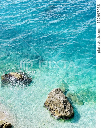 Rocky beach and crystal turquoise water of Ionian Sea in Albania. 112997088