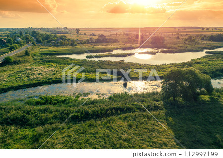 Aerial view of the brook on the meadow. The countryside in spring. Rural landscape in the evening 112997199