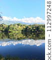 Blue sky and clouds reflected on the surface of the water 112997248