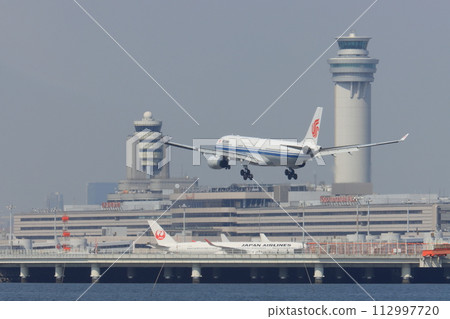 Passenger plane landing at Haneda Airport 112997720