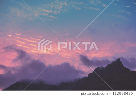 Silhouette of mountains against the purple sunset sky. Norway nature 112998430