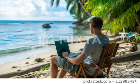 Man Working on Laptop at Tropical Beach 112998454