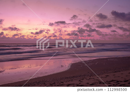 Seascape in the early morning. Sunrise on a sandy beach with beautiful sky 112998500